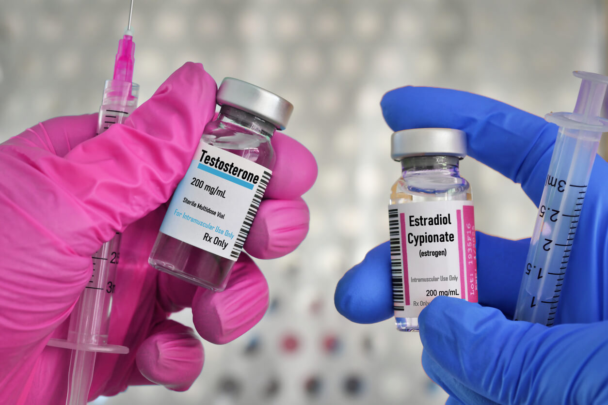 Person holding vials of testosterone and estradiol